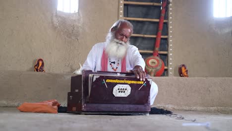 Scene-from-front-showing-an-Indian-saint-playing-a-harmonium-box-singing-traditional-hymns-and-giving-a-message-to-the-people