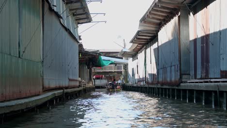 Eine-Gruppe-Von-Touristen-Unternimmt-Eine-Bootsfahrt-In-Einem-Holzboot-Im-Kanal-Des-Schwimmenden-Marktes-Damoen-Saduak,-Thailand