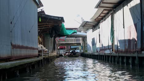 Zoomen-Sie-Auf-Ein-Holzboot,-Das-Im-Kanal-Des-Schwimmenden-Marktes-Damoen-Saduak-In-Thailand-Fährt