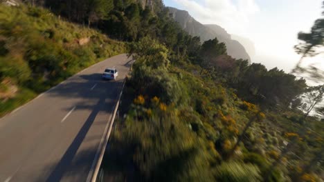 Picturesque-FPV-aerial-following-a-car-driving-along-a-scenic-coastal-road-in-Mallorca