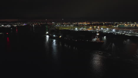 Drohnennacht-Fliegt-über-Wasser-Mit-Einem-Containerschiff,-Das-Aus-Dem-Newport-Yarra-River-Kommt