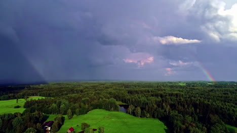 Regenbogen-Im-Dunklen-Bewölkten-Himmel-über-Grüner-Landschaft-Aus-Bäumen-Und-Einem-See