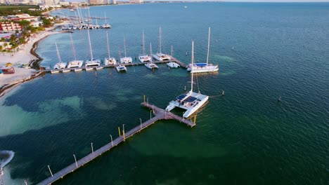 Aerial-Drone-Flyover-Luxury-Yacht-Harbor-With-Blue-Ocean-In-Cancun,-Mexico,-4K