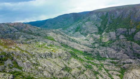 Aerial-trucking-pan-of-rio-tera-canyon,-green-vegetation-cut-across-exposed-rock