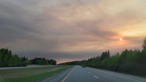 Fox-creek-town-outskirts-on-highway,-haze-smoke-sky-sunset-alberta-canada