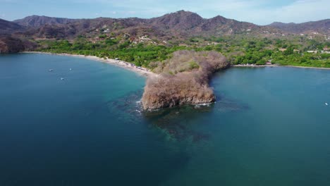 Scenic-Rocky-Cliff-Headland-With-Turquoise-Blue-Ocean-And-Scenic-Green-Trees-In-Distance,-4K-Drone-Costa-Rica-Coast