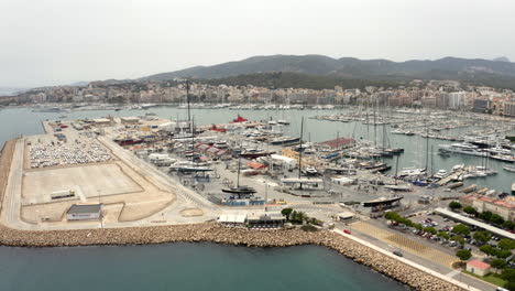 Palma-city-port-area-with-piers,-anchored-boats-and-car-parking-lot
