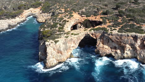 Rocky-coast-with-eroded-cliffs-and-arches-above-sea-waves-in-Mallorca