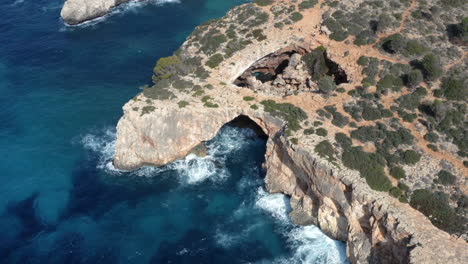 Rock-cliffs-above-sea-waves-with-arches-formed-due-to-water-erosion