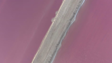 Sandy-causeway-between-salt-evaporation-ponds-gone-pink-with-algae