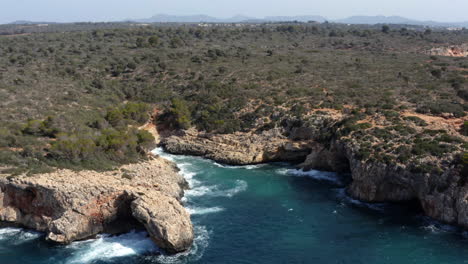 Sea-lagoon-wedged-between-rock-cliffs-eroded-by-sea-waves-in-Mallorca