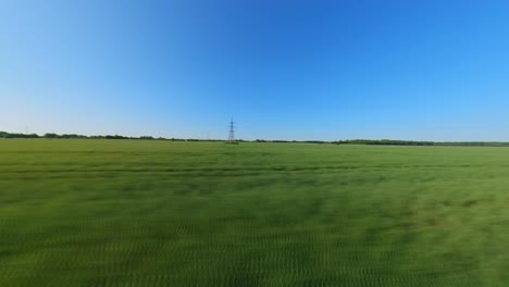 Hyperlapse-Shot-of-High-Voltage-Power-Transmission-Line-Poles-in-Green-Agricultural-Fields