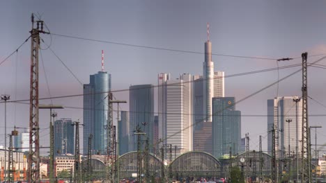 Frankfurt-railway-station-and-power-poles-in-front-of-city-skyline,-static