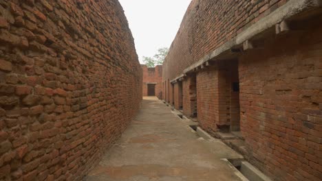 In-Einer-Engen-Gasse-Eines-Zerstörten-Klosters-Mit-Komplizierten-Mauerwerkswänden-Und-Räumen,-Die-An-Der-Stelle-Von-Nalanda-Mahavihara,-Einer-Alten-Buddhistischen-Klosteruniversität-In-Bihar,-Indien,-Ausgegraben-Wurden