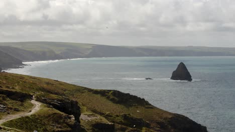 Extraweite-Aufnahmen-Der-Küste-Cornwalls,-Die-In-Der-Ferne-Verschwindet,-Mit-Möwenfelsen-Und-Küstenwiese-Im-Vordergrund