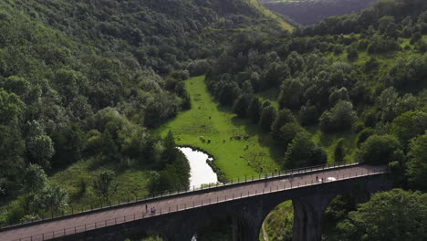 Aerial-view-tilting-backwards-over-the-railway-viaduct-at-Monsal-Head,-in-England