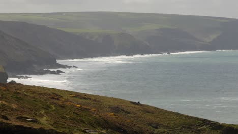Extraweite-Aufnahmen-Der-Küste-Cornwalls-Mit-Wellen,-Die-An-Den-Strand-Krachen,-Mit-Küstenwiese-Im-Vordergrund