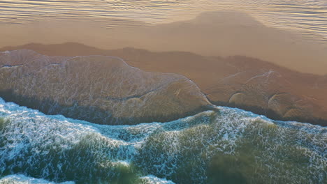 Aerial-view-above-waves-at-the-K'gari-beach-on-Fraser-island,-in-sunny-Australia---top-down,-drone-shot
