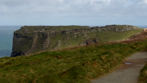 Extra-Wide-shot-looking-at-Tintagel-cliffs-with-coastal-path-in-foreground,-from-Lower-Penhallic-Tregatta