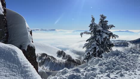 Nach-Unten-Geneigte-Aufnahme-Einer-Atemberaubenden-Winterlandschaft-Mit-Blick-Auf-Ein-Wolkiges,-Schneebedecktes-Tal-Vom-Gipfel-Eines-Skigebiets-In-Den-Rocky-Mountains-Von-Utah-An-Einem-Hellen,-Warmen,-Sonnigen-Frühlingstag