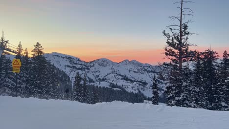 Handaufnahme-Einer-Atemberaubenden-Winterlandschaft-Mit-Blick-Auf-Ein-Wolkiges,-Schneebedecktes-Tal-Während-Eines-Goldenen-Sonnenuntergangs-Vom-Gipfel-Eines-Skigebiets-In-Den-Rocky-Mountains-Von-Utah-An-Einem-Windigen-Abend