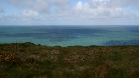 shot-of-the-Cornish-Cliff-edge-overlooking-torquoise-sea-and-blue-sky,-from-Lower-Penhallic-Tregatta