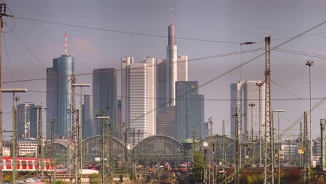 Red-train-arrives-at-Frankfurt-rail-station,-panorama-skyline-view,-static-shot