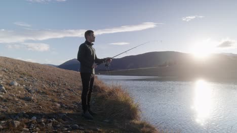 Young,-lonesome-fisherman-casting-out-rod-at-golden-hour