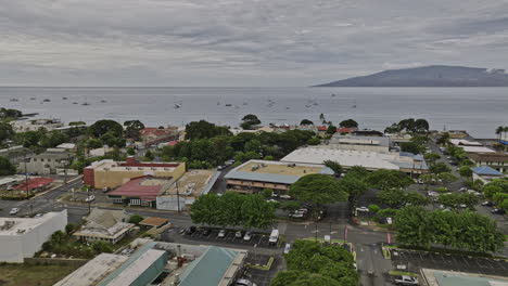 Lahaina-Maui-Hawaii-Aerial-v5-establishing-shot,-drone-low-level-flyover-town-center-overlooking-at-Molokaʻi-Island-across-the-sea-above-the-horizon---Shot-with-Mavic-3-Cine---December-2022