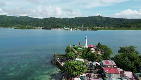 White-lighthouse-in-exotic-bay-on-the-Philippines,-aerial-orbit-sunny-day