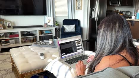 Rear-view-of-Hispanic-female-business-woman-working-from-home-in-the-comfort-of-her-living-room