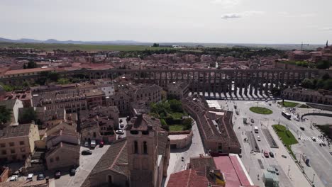 Aerial-View-Over-Aqueduct-Of-Segovia-Beside-Plaza-Oriental-With-Traffic-Going-Around-Av