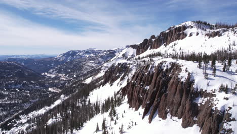 Drone-Shot-of-Rocky-Cliffs,-Mountain-Pass-and-Snow-Capped-Landscape-of-Colorado-on-Sunny-Winter-Day