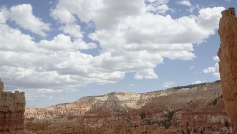 Handgeführte-Landschaftsaufnahme-Einer-Wunderschönen-Wüste-Aus-Orangefarbenen-Und-Weißen-Sandsteinformationen-Im-Süden-Utahs-An-Einem-Wolkigen,-Warmen,-Sonnigen-Sommertag