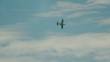 Un-Pequeño-Avión-Vuela-Por-El-Cielo-Azul-Con-Nubes