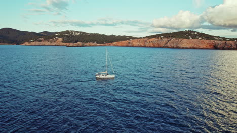 Velero-Flotando-En-El-Mar-Azul-Cerca-De-Punta-Galera-En-Ibiza,-España