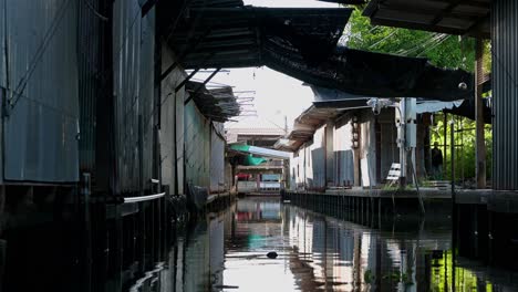 Passing-by-the-closed-souvenir-shops-in-the-canals-of-Damnoen-Saduak-Flaoting-Market-in-Thailand,-while-on-a-boat-ride