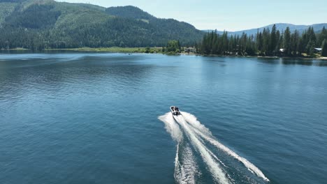 Drone-shot-of-a-motorboat-traveling-through-Spirit-Lake-in-Idaho