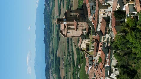 Vista-Aérea-De-La-Torre-Del-Reloj-De-La-Iglesia-Parroquial-En-La-Ladera-De-Ozzano-Monferrato,-Italia