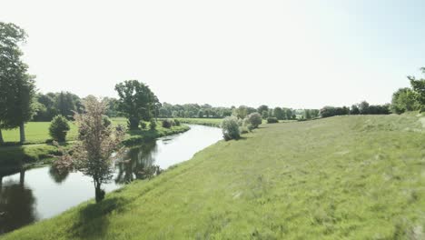 Grasbewachsener-Hügel-Am-Ufer-Des-Flusses-Slaney-Mit-Dem-Ackerland-In-Wexford,-Irland