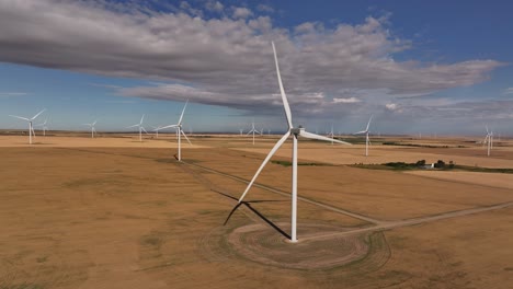 A-drone-flies-up-to-a-windmill-on-a-wind-farm-in-southern-Alberta,-Canada