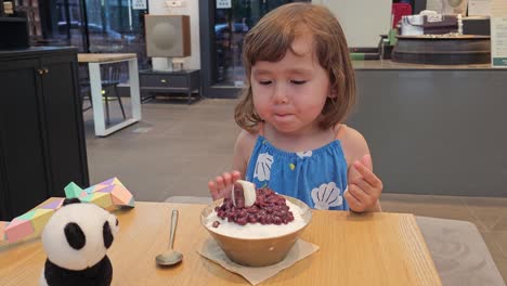 Cute-Toddler-Girl-Trying-to-Eat-Korean-Shaved-Ice-Dessert-with-Sweet-Red-Beans-Topping