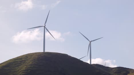 Two-wind-turbines-spinning-on-a-hill-in-New-Zealand