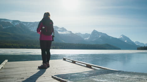 Female-Backpacker-Takes-Pictures-of-Sunny-Maligne-Lake-and-Mountains