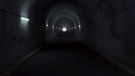 Aerial-flying-through-a-long-tunnel-with-light-in-the-horizon