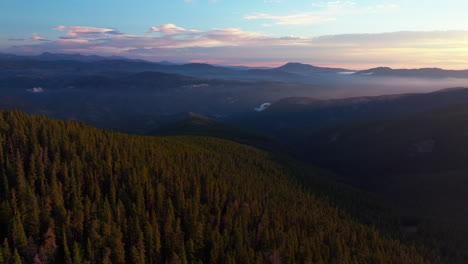 Cinematic-aerial-drone-sunrise-morning-sun-flare-Denver-front-range-foothills-Rocky-Mountains-layers-i70-Idaho-Springs-Evergreen-Mount-Evans-14er-wilderness-Squaw-pass-Echo-Mountain-circling-right