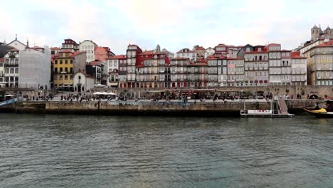 Sliding-view-of-Cais-da-Ribeira-with-beautiful-colorful-houses-and-Rabelo-boats,-Porto