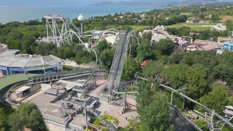 Drone-dolly-above-amusement-park-roller-coaster-tracks-on-beautiful-Italian-day