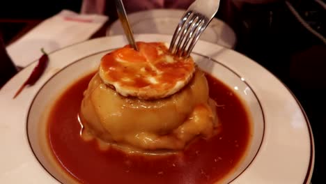 Traditional-francesinha-dish-being-cut-to-reveal-its-ingredients-at-dinner