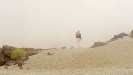 Mujer-Solitaria-Caminando-Hacia-Una-Profunda-Niebla-En-El-Desierto-Del-Parque-Nacional-Del-Teide